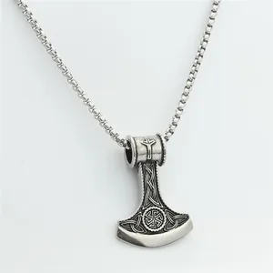 Macro detail of stainless steel Thor's hammer pendant with Kolovrat sun wheel symbol