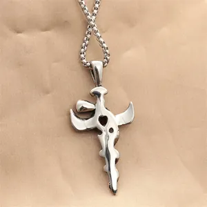 Gothic silver sword cross pendant necklace with red heart stone on beige background