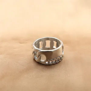 Detailed view of silver stainless steel wide ring with Cuban link texture on silk fabric