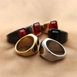 Detailopname van vintage punk ringen met rode en zwarte edelstenen op zijden stof