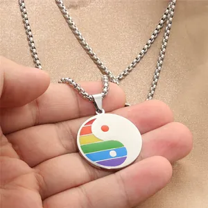 Gros plan d'un pendentif Tai Chi en acier inoxydable avec couleurs arc-en-ciel et chaîne