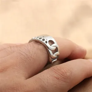 Close-up of a wide stainless steel Cuban chain ring worn on a finger with a mirror finish
