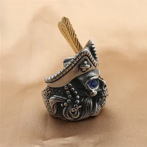 Macro view of vintage skull ring with blue gemstone eye and golden feather detail