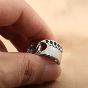 Macro shot of silver stainless steel ring featuring Cuban chain link and polished surface