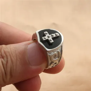 Detail showing vintage black enamel signet ring with silver dotted cross and floral relief