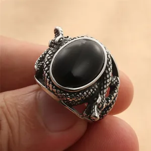 Detailed close-up of a vintage punk snake ring with a large oval black stone and scales