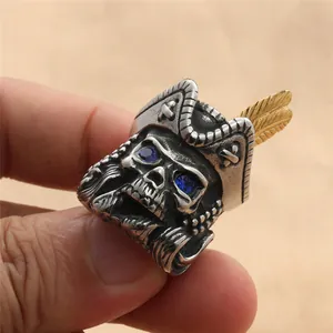 Close-up of a vintage pirate skull ring with gold feather and blue gem eyes