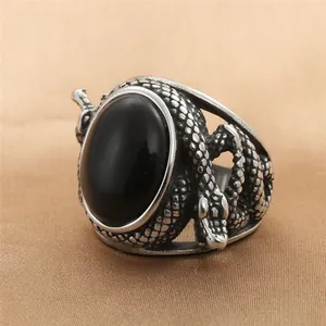 Macro shot of the black oval stone and snake scale texture on the vintage steel ring