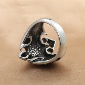 Retro punk titanium steel skull ring with hollow flame patterns on brown silk fabric