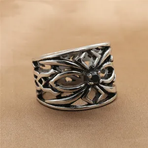 Close-up of vintage镂空 steel ring with spider pattern and a round black gemstone inlay