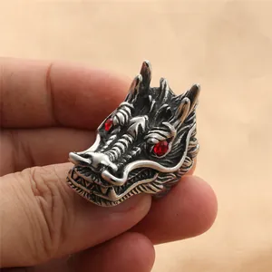 Detail of vintage dragon ring in stainless steel with red eyes and textured metal finish
