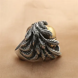 Gedetailleerd zicht op zilveren vedertexturen met gouden kraal op deze vintage punk ring
