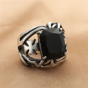 Macro-opname van retro roestvrijstalen ring met zwarte edelsteen en kruisdetail