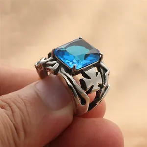 Macro-opname van retro punk stalen ring met blauwe steen en uitgesneden kruis-patroon