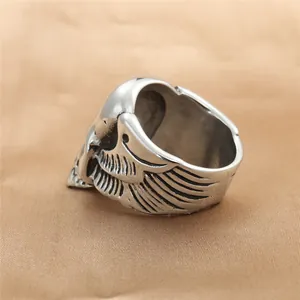 Retro punk titanium steel skull ring with wing relief on golden velvet fabric