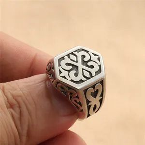 Macro shot of vintage titanium steel hexagonal ring featuring detailed tribal carvings