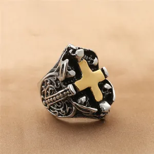 Detalle del anillo gótico vintage de calavera con cruz dorada y textura punk de acero