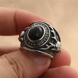Macro detail of vintage stainless steel college ring with black stone and deer relief