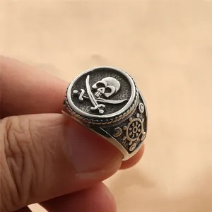 Macro shot of retro silver skull and crossbones ring with a nautical rudder motif