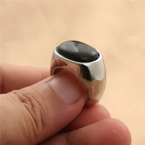Primer plano de anillo de sello en acero pulido con piedra de ónix negro ovalada