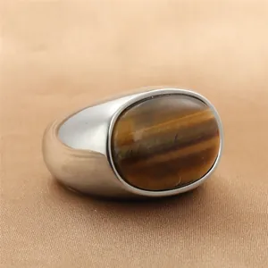 Detalle macro de piedra ojo de tigre ovalada engastada en anillo de sello de acero pulido
