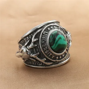 Macro view of vintage stainless steel ring featuring green stone and deer head engraving