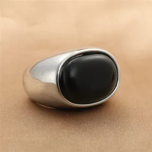 Vista detallada de un anillo vintage ovalado con piedra negra sobre satén color champán