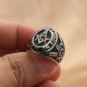 Vue macro d'une bague maçonnique vintage avec équerre et compas portée au doigt