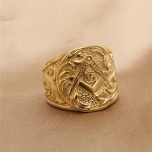 Gros plan sur une bague maçonnique dorée avec symbole G et gravures florales