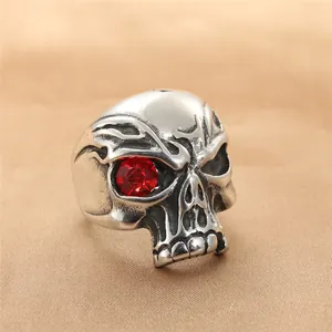 Vintage stainless steel skull ring with red rhinestone eye on silk background