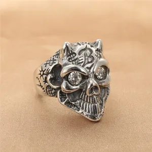 Detail of gothic skull ring in vintage steel finish with gemstone eyes and engraved B