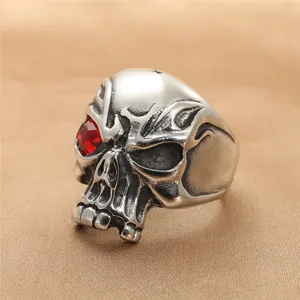 Macro detail of vintage punk skull ring with red gemstone eye and silver steel finish