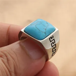 Primer plano detallado de un anillo de sello con turquesa cuadrada y greca grabada