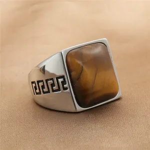 Detalle macro del anillo vintage para hombre con ojo de tigre y motivo de greca negra