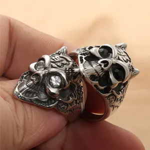 Detailed view of punk skull rings with clear and black inlaid gemstones for men