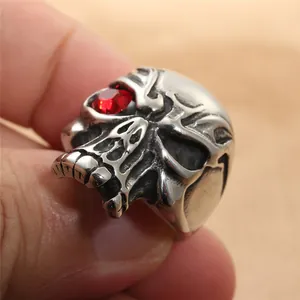 Close-up of vintage punk skull ring in black stainless steel with a red gemstone eye
