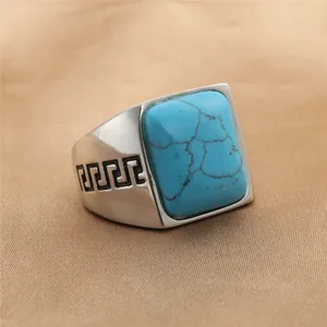 Primer plano de anillo vintage con turquesa cuadrada y patrones de greca griega