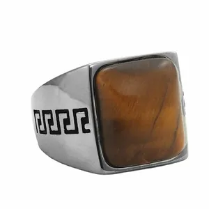 Detalle macro de piedra ojo de tigre cuadrada en anillo de acero con patrón de greca griega