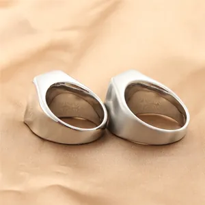 Dettaglio di anelli minimalisti in acciaio argento con finiture lucide e spazzolate