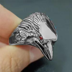 Detailed view of punk eagle head ring in vintage steel with striking red gemstone eyes