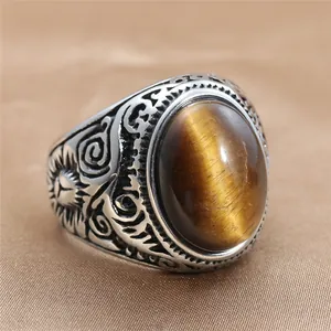 Foto macro de anillo vintage de acero con patrones de sol e incrustación ojo de tigre