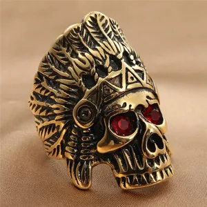 Detail of golden skull ring with red eye stones and tribal feather headdress engraving