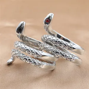 Macro shot of punk style stainless steel snake ring with red and black crystal eyes