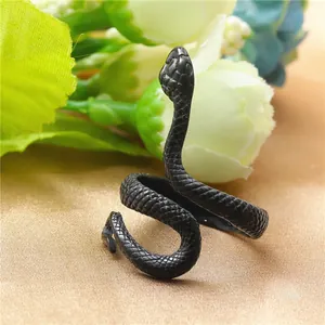 Détail macro d'une bague serpent en acier noir montrant des textures d'écailles précises