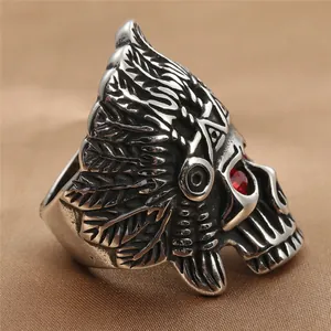 Detailed side view of punk skull ring with red gems and ornate feather headpiece