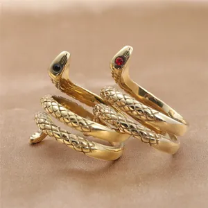 Detail of snake ring with gold scaling and red and black gemstone eyes in punk style