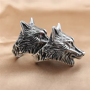 Detailed close-up of retro wolf head rings in vintage silver finish with red stone eyes