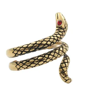 Macro shot of gold snake ring with detailed scale texture and striking red stone eyes