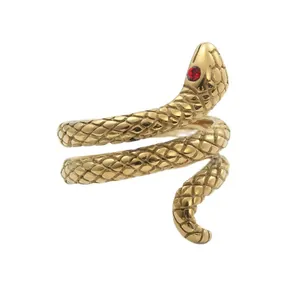 Macro view of golden coiled snake ring featuring red gemstone eye and scale textures