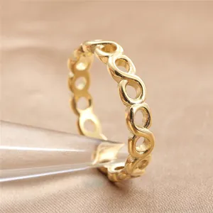 Macro di un anello dorato a infinito su cono di vetro con sfondo di seta